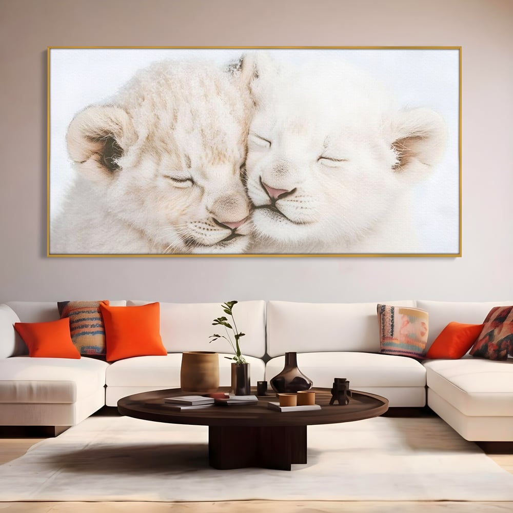 Tablou canvas cu doi pui de leu dormind imbratisati, in rama de aluminiu auriu, pe perete intr-un living